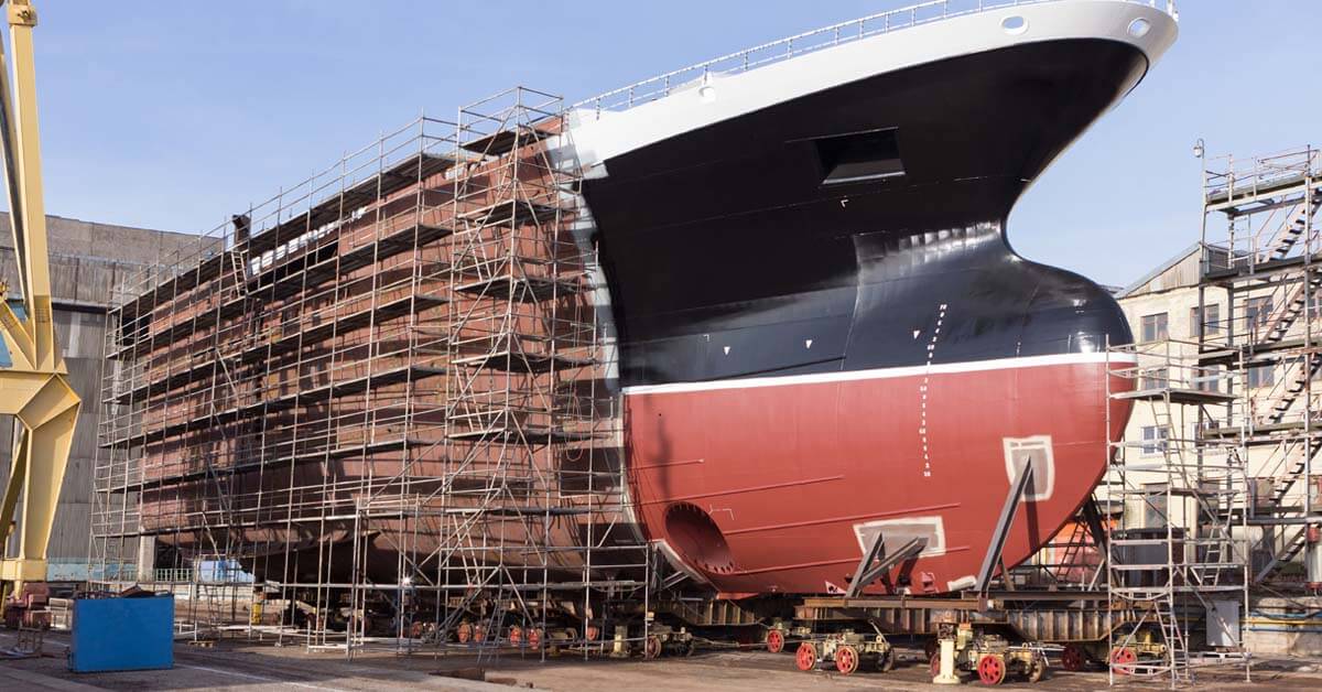 Welder working on the hull of a large ship
